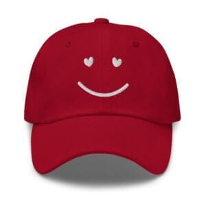 Red baseball cap with embroidered smiley face