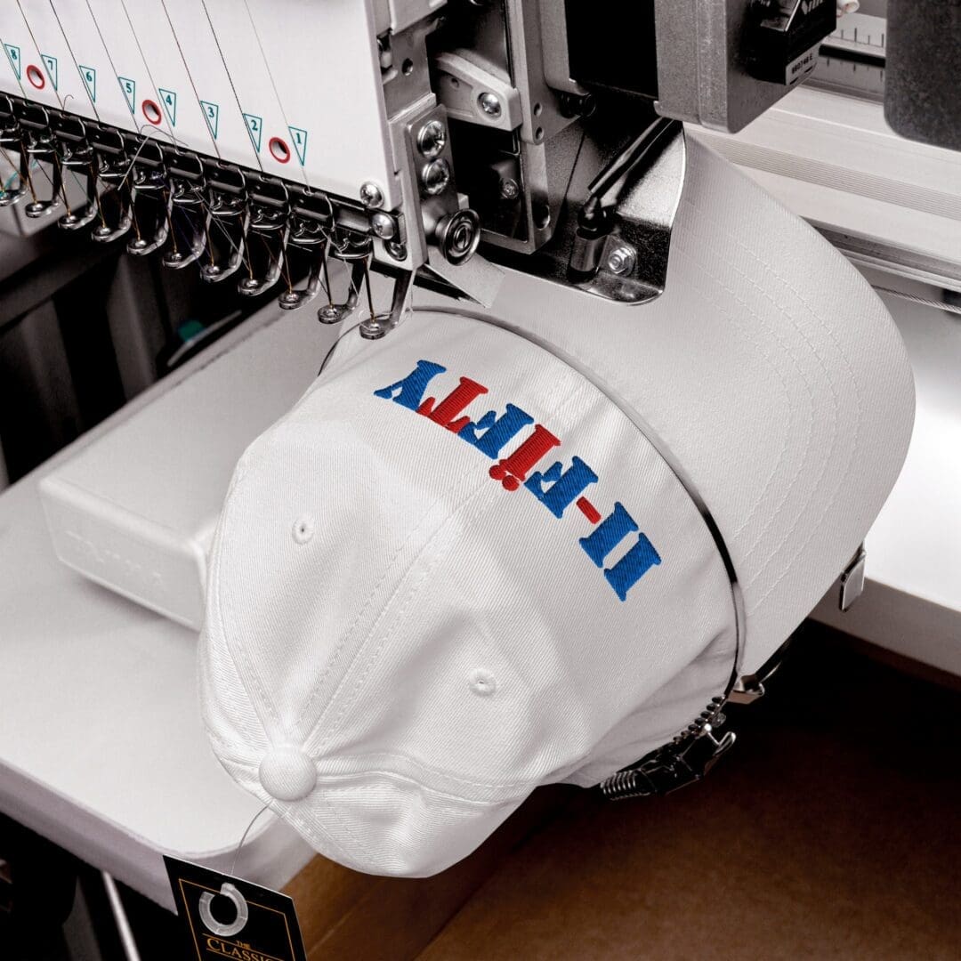 Embroidery machine stitching a white baseball cap
