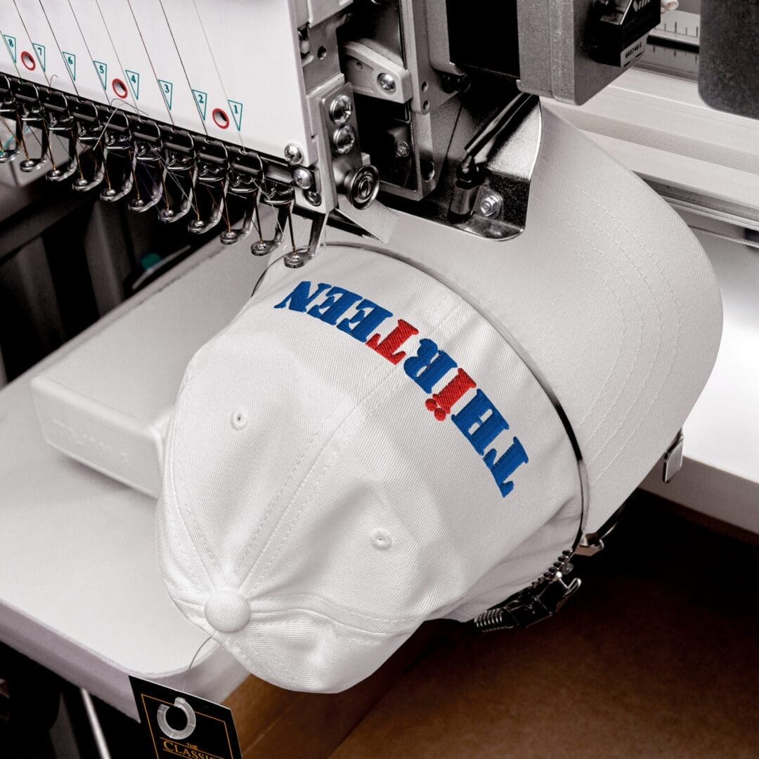 Embroidery machine stitching a white cap
